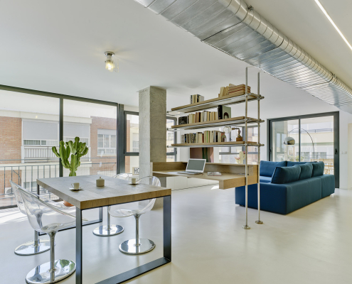Comedor-estudio-salón Vista de comedor y salón con estantería intermedia en reforma integral AyM